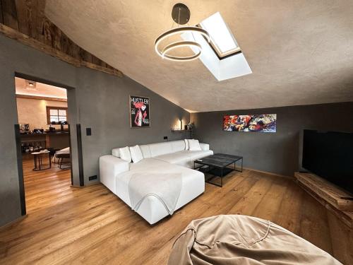 a living room with a white couch and a television at Panorama Chalet Ehrwald in Ehrwald