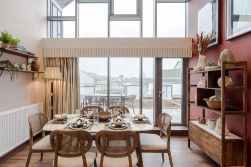 a dining room with a table and chairs and a large window at Waterside Living I Luxe Apartments in Bristol