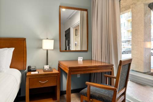 a bedroom with a desk and a bed and a mirror at Vagabond Inn Glendale in Glendale