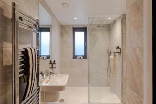 a bathroom with a sink and a shower at Waterside Living I Luxe Apartments in Bristol