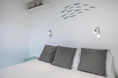a bedroom with a white bed with gray pillows at Hotel Nathalie in Ixia