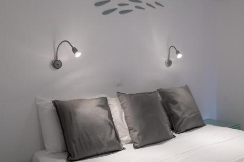 a bed with two pillows and two lights above it at Hotel Nathalie in Ixia