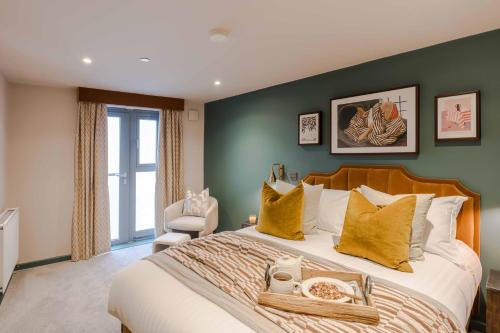 a bedroom with a large bed with yellow pillows at Waterside Living I Luxe Apartments in Bristol