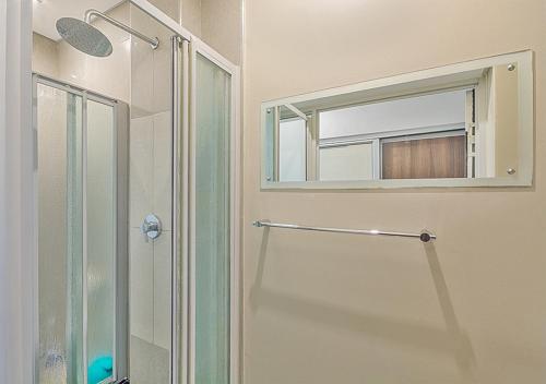 a bathroom with a shower and a mirror at Stylish Genisis on Fairmount U15 in Johannesburg
