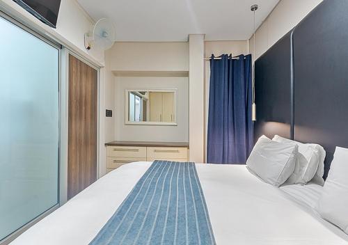 a bedroom with a large bed and a mirror at Stylish Genisis on Fairmount U15 in Johannesburg