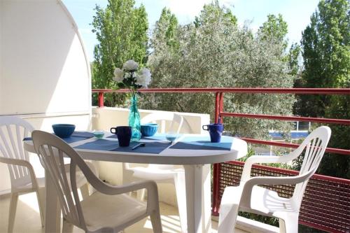 d'une table blanche avec des chaises et un vase de fleurs sur le balcon. dans l'établissement Appt Studio LA ROCHELLE - LR010-113, à La Rochelle