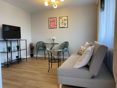 a living room with a couch and a table at Przytulne Mieszkanie w Centrum in Jastrzębie Zdrój