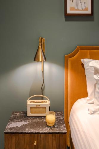 a lamp on a table next to a bed with a radio at Waterside Living I Luxe Apartments in Bristol