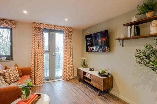 a living room with a couch and a table at Waterside Living I Luxe Apartments in Bristol