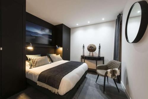 une chambre avec un grand lit et un miroir dans l'établissement Alpohi, à Paris