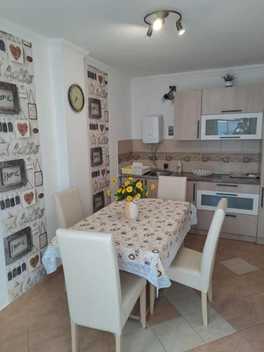 jadalnia ze stołem i krzesłami oraz kuchnia w obiekcie Katarina apartman w Hajduszoboszlo