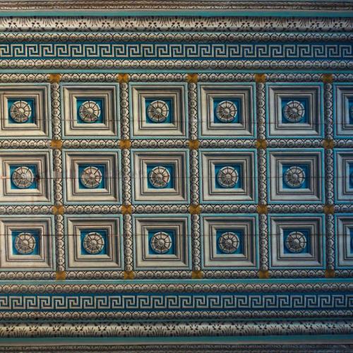 an ornate ceiling in a building with a pattern at 1900 Hotel in Symi