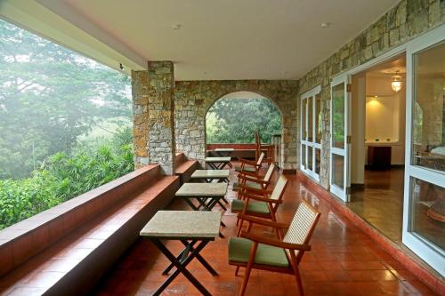 a row of chairs and tables in a room with a window at Villa Mahakanda in Peradeniya