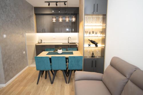 a kitchen with a table and some blue chairs at Favorit apartman in Trebinje