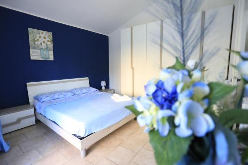 a bedroom with a bed with blue walls and blue flowers at Ranieli Apartments a meno di 2 kilometri da TROPEA FREE PARKING AND WIFI in Drapia