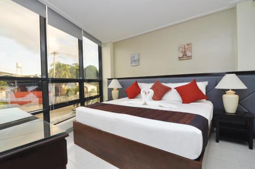 a bedroom with a large bed and a large window at 717 Cesar Place Hotel in Tagbilaran City