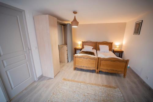 a bedroom with a wooden bed and a door at Hermine appartement 4 personnes in Vroncourt
