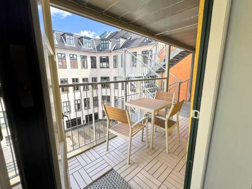 a balcony with a table and chairs and a building at Perfect Apartment for Friends & Families in central Copenhagen in Copenhagen