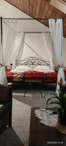 a bedroom with a bed with curtains and a table at Hotel Plzeňský Dvůr in Frýdek-Místek
