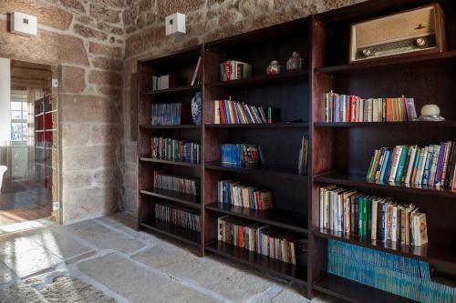 a library with wooden shelves filled with books at Casas Novas Countryside Hotel Spa & Events in Chaves