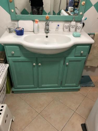 a bathroom with a green vanity with a sink at Casa Azzurra in Porto San Paolo