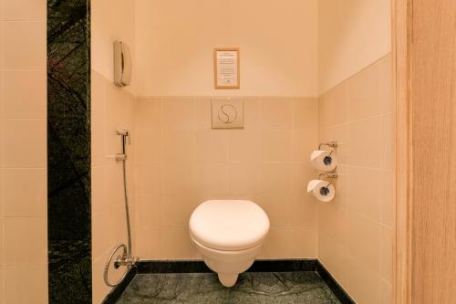 a bathroom with a toilet and a shower at Lemon Tree Hotel, Gachibowli, Hyderabad in Hyderabad