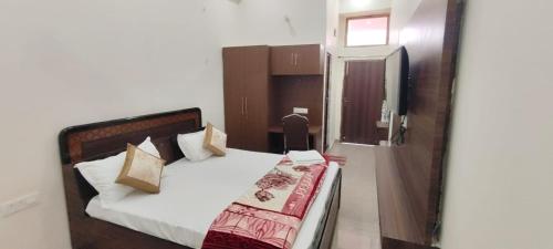 a bedroom with a bed and a refrigerator at Hotel Subhadra in Kannauj