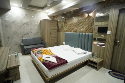 a hotel room with a bed and a chair at Hotel New Sundaram 150 Mtrs from Dargah in Ajmer