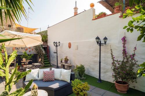 a patio with a couch and some plants and lights at A Ugghia in Fiumefreddo di Sicilia