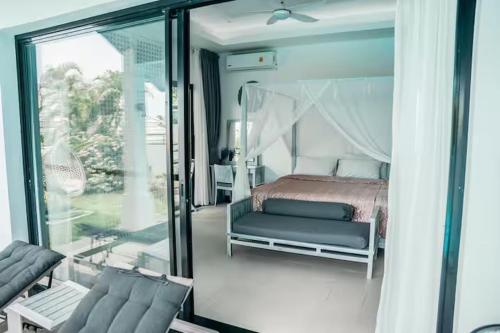 a bedroom with a bed and a sliding glass door at Villa Cannes with gym and tennis court in Choeng Mon Beach