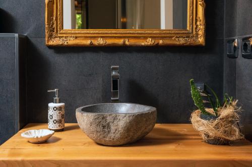 a bathroom with a stone sink and a mirror at A Ugghia in Fiumefreddo di Sicilia