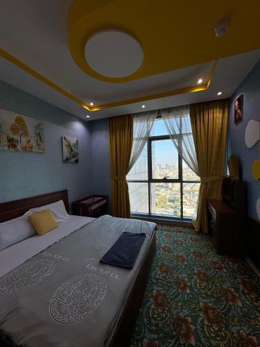 a bedroom with a bed and a large window at Blue Horizon Stays at Ajman Corniche in Ajman