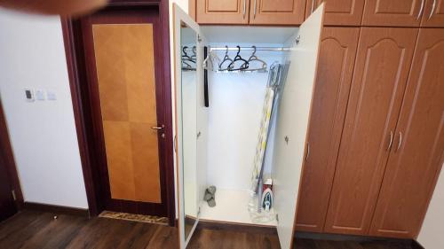 a closet with a glass door next to a cabinet at Blue Horizon Stays at Ajman Corniche in Ajman