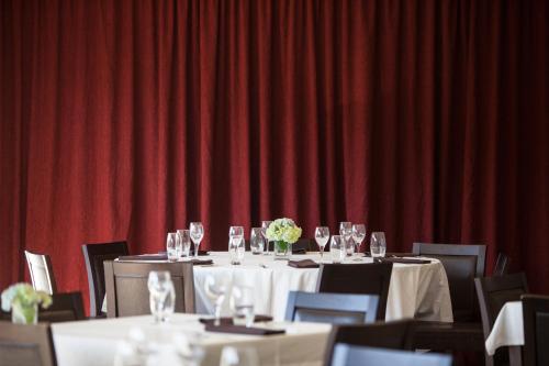 a dining room with tables and chairs with wine glasses at Casas Novas Countryside Hotel Spa & Events in Chaves