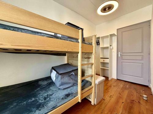 Cette chambre comprend 2 lits superposés et une porte. dans l'établissement Mais 3 pièces 4 couchages - Saint Georges d'Oléron SGO000-458, à Saint-Georges-dʼOléron