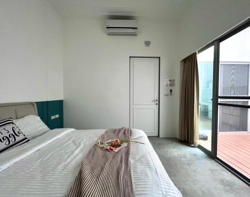 a bedroom with a bed and a large window at 隨緣居民宿 in Zhongpu