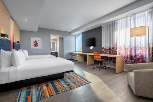 a hotel room with a bed and a desk at Aloft Columbia Downtown in Columbia