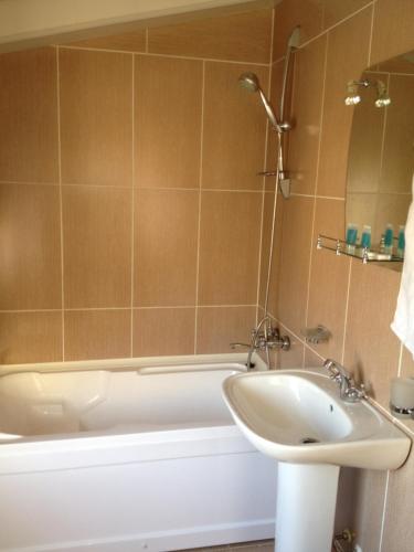 a bathroom with a white tub and a sink at Hotel Corner in Tbilisi City