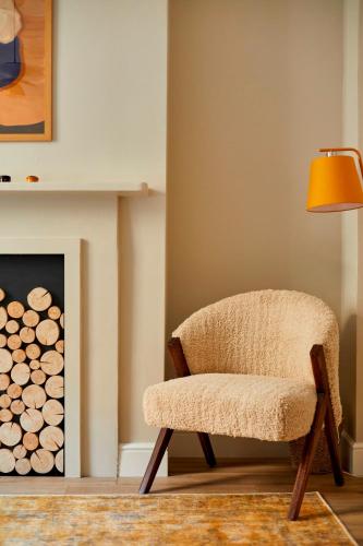 a chair next to a fireplace with a lamp at Georgian House Hotel in London