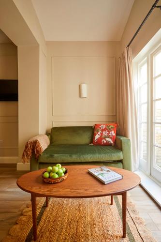 a living room with a green couch and a table at Georgian House Hotel in London