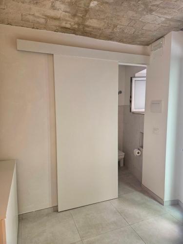 an empty room with a white wall and a toilet at La Stanza di Chiara - Maison à Porter in Vasto