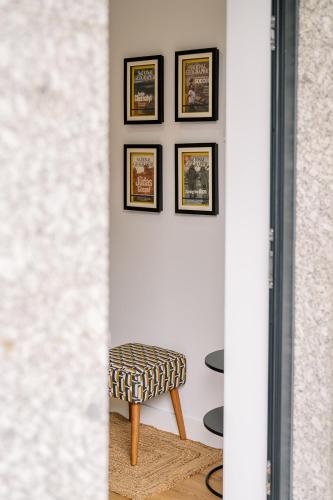 a room with a stool and pictures on the wall at Boutique Home Barca in Ponte da Barca
