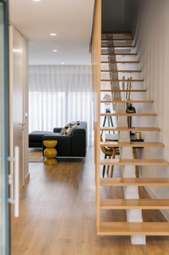 a spiral staircase in a living room with a couch at Boutique Home Barca in Ponte da Barca