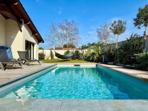 - une piscine à côté d'une maison dans l'établissement Sublime maison de vacances piscine au cœur des pins, proche plage, à La Teste-de-Buch