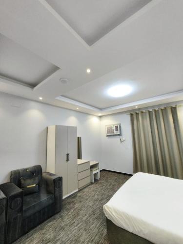a hotel room with a bed and a couch and a desk at Al Rayhan Suites الريحان للأجنحة المفروشة in Al Madinah
