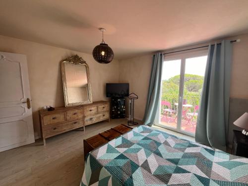 une chambre avec un lit, un miroir et une fenêtre dans l'établissement Maison 3 chambres avec piscine dans un jardin luxuriant, à Puget-sur Argens