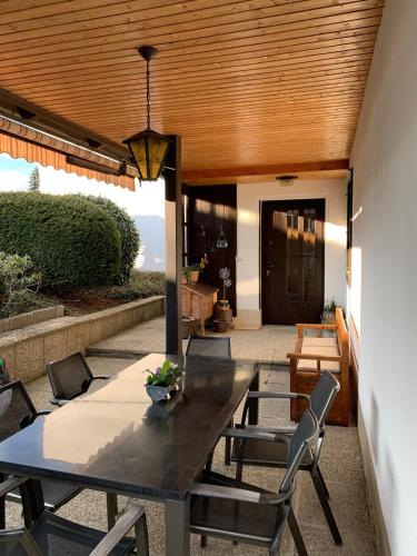 a patio with a wooden ceiling and a table and chairs at Chalet Wienerwald in Königstetten