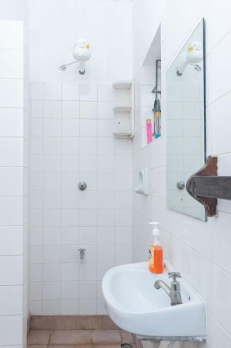 a white bathroom with a sink and a mirror at Zing gardens E06 in Mombasa