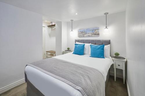 a bedroom with a large bed with blue pillows at Host & Stay - The Courtyard Retreat in Whitby