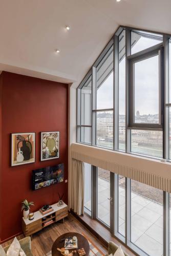 a living room with red walls and large windows at Waterside Living I Luxe Apartments in Bristol